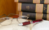 Image of glasses resting on an open journal in front of a stack of boxes